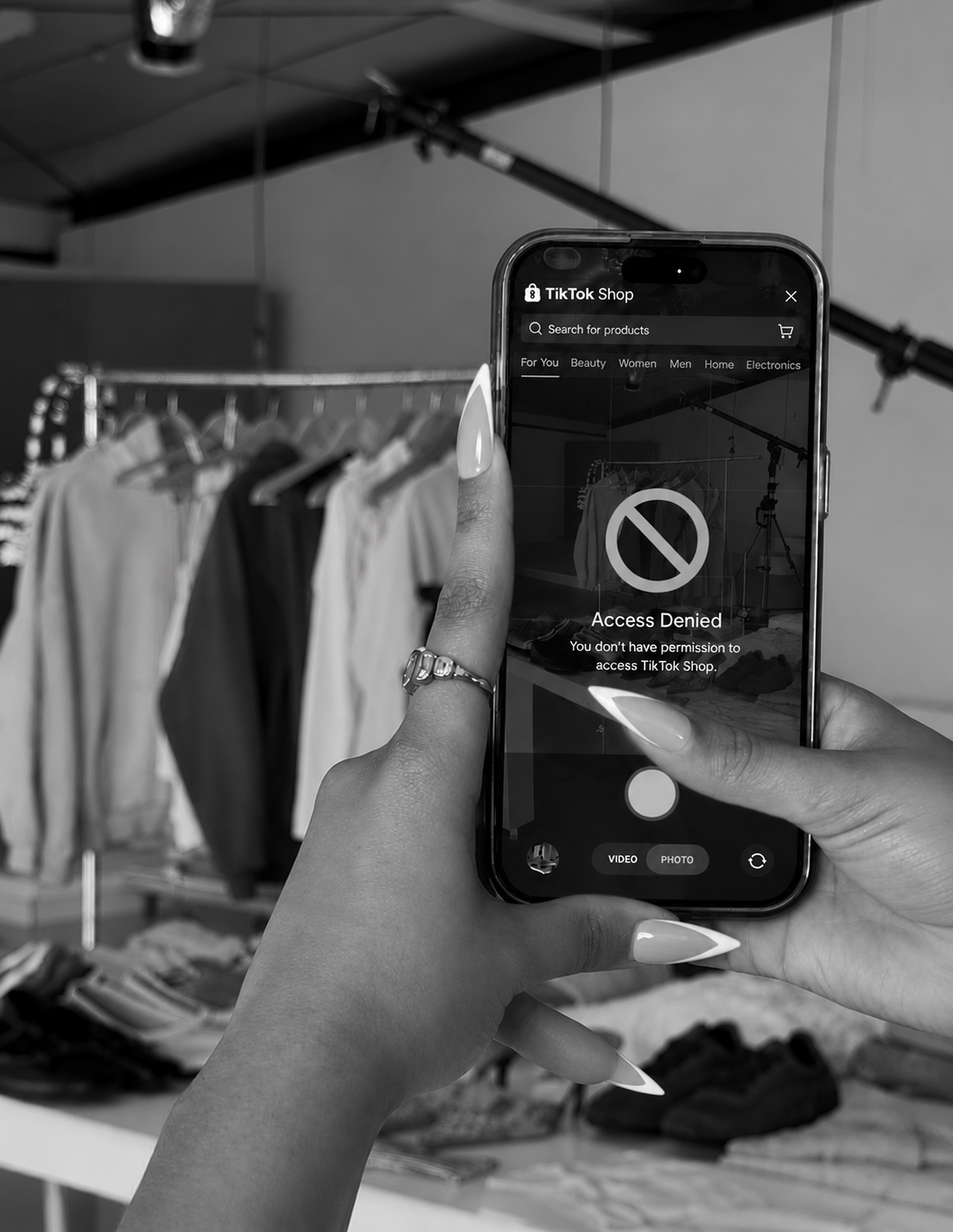 A  woman's hand holding a smartphone with an "Access denied" notification displayed on the screen.